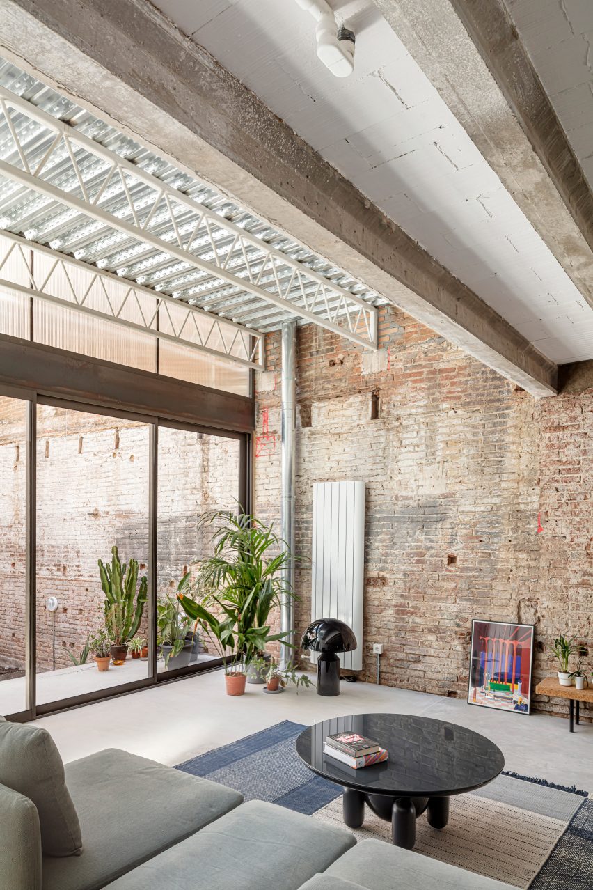 Living room with a brick wall and exposed ceiling beams