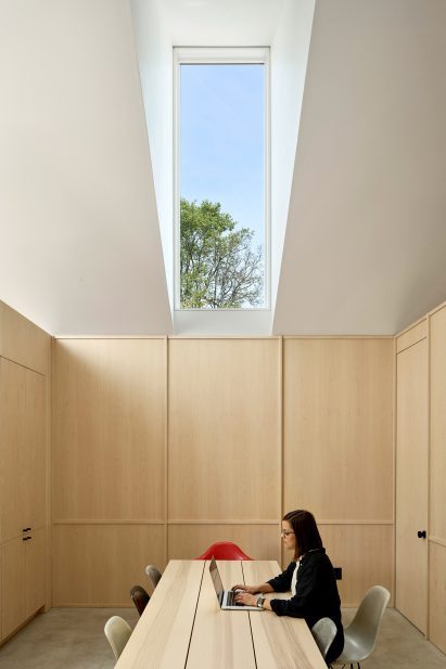 Woman working below tall monitor window