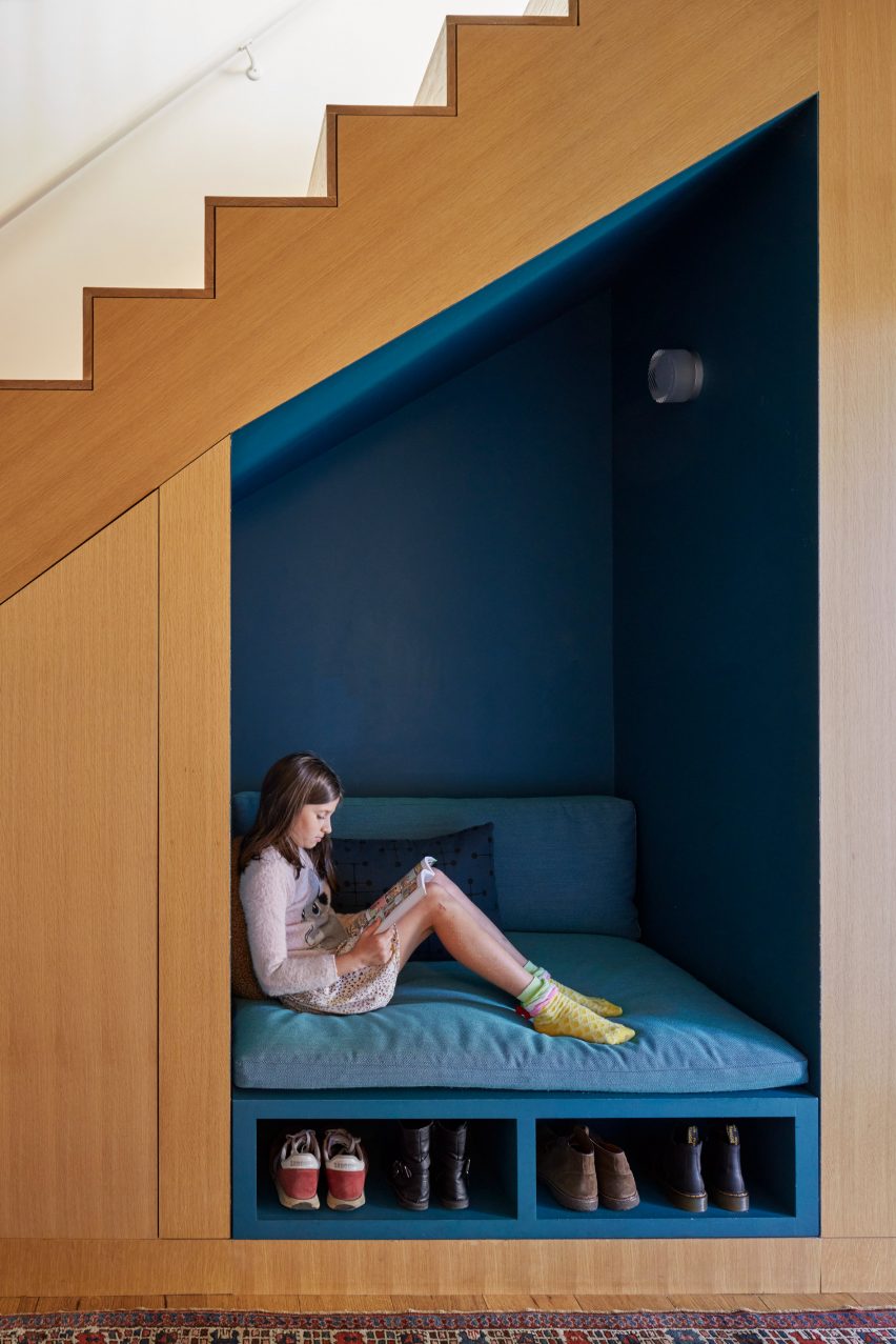 A child sitting underneath stairs