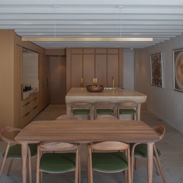 Dining room with wooden furniture in front of a travertine kitchen island