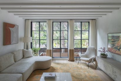 Living room with three large windows overlooking a patio