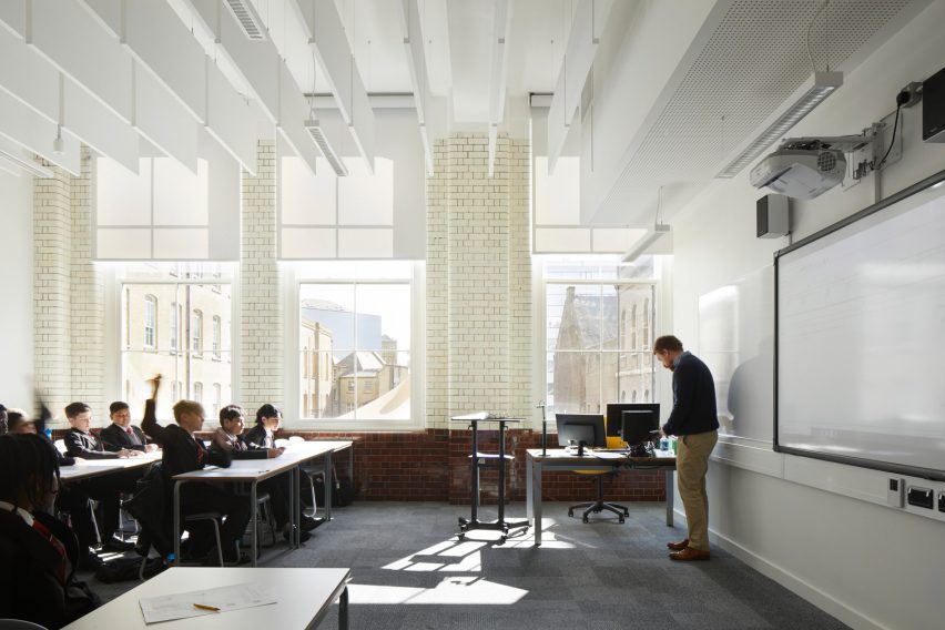 Teacher presenting to pupils in a white classroom