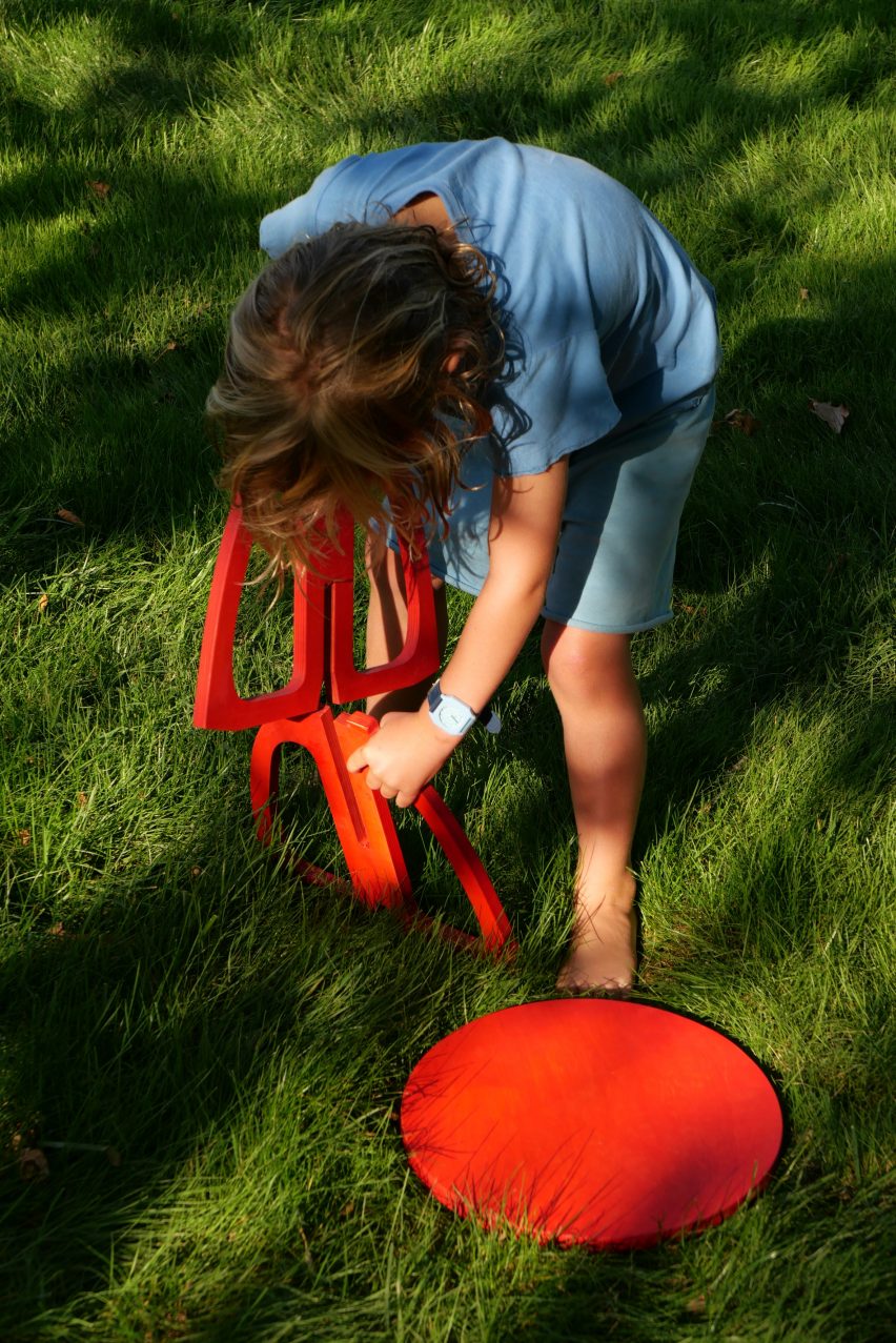 A child assembling a red chair