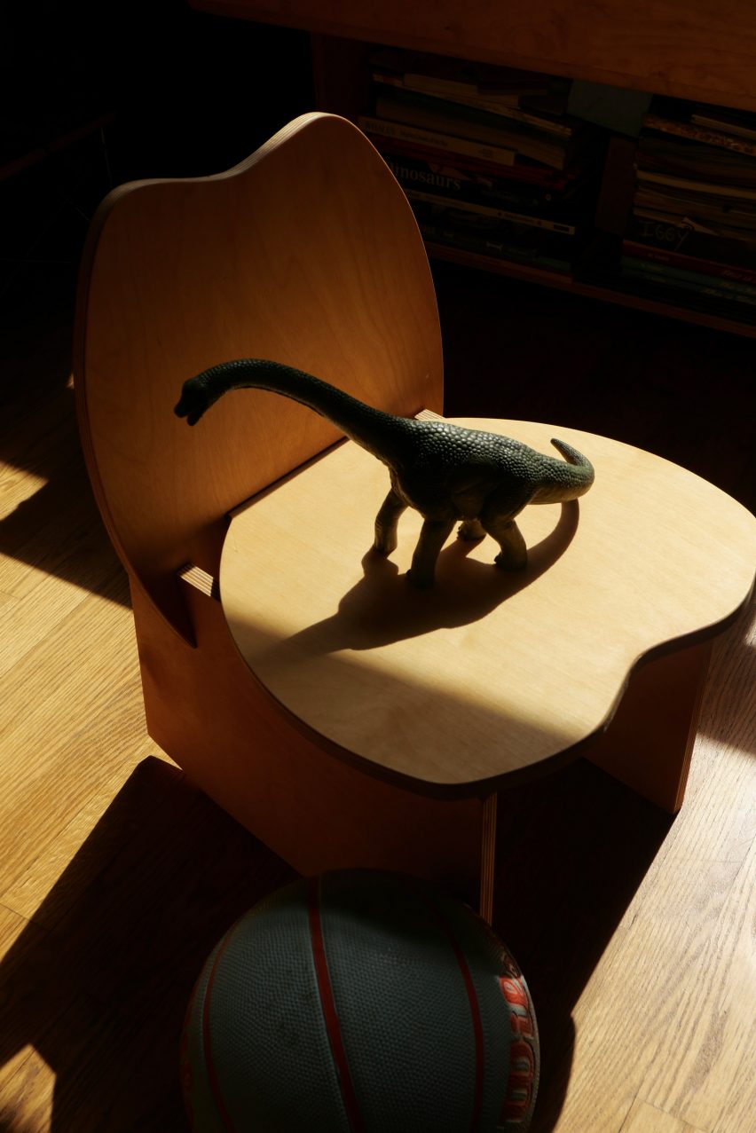 A blocky wooden chair with a dino on top