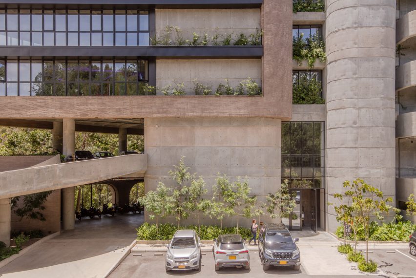 Concrete office building with plants and parked cars