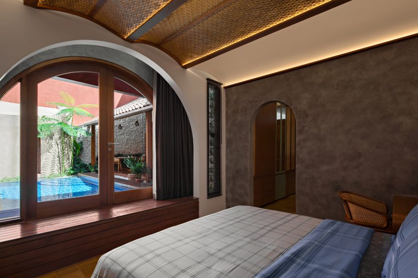 Bedroom with an arched window overlooking a swimming pool
