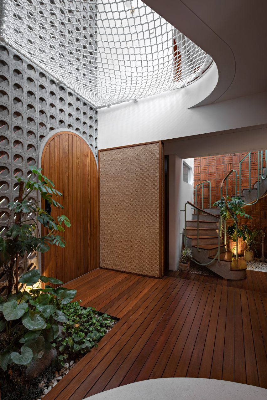 Concrete and wood light well at Distracted House by Ismail Solehudin Architecture