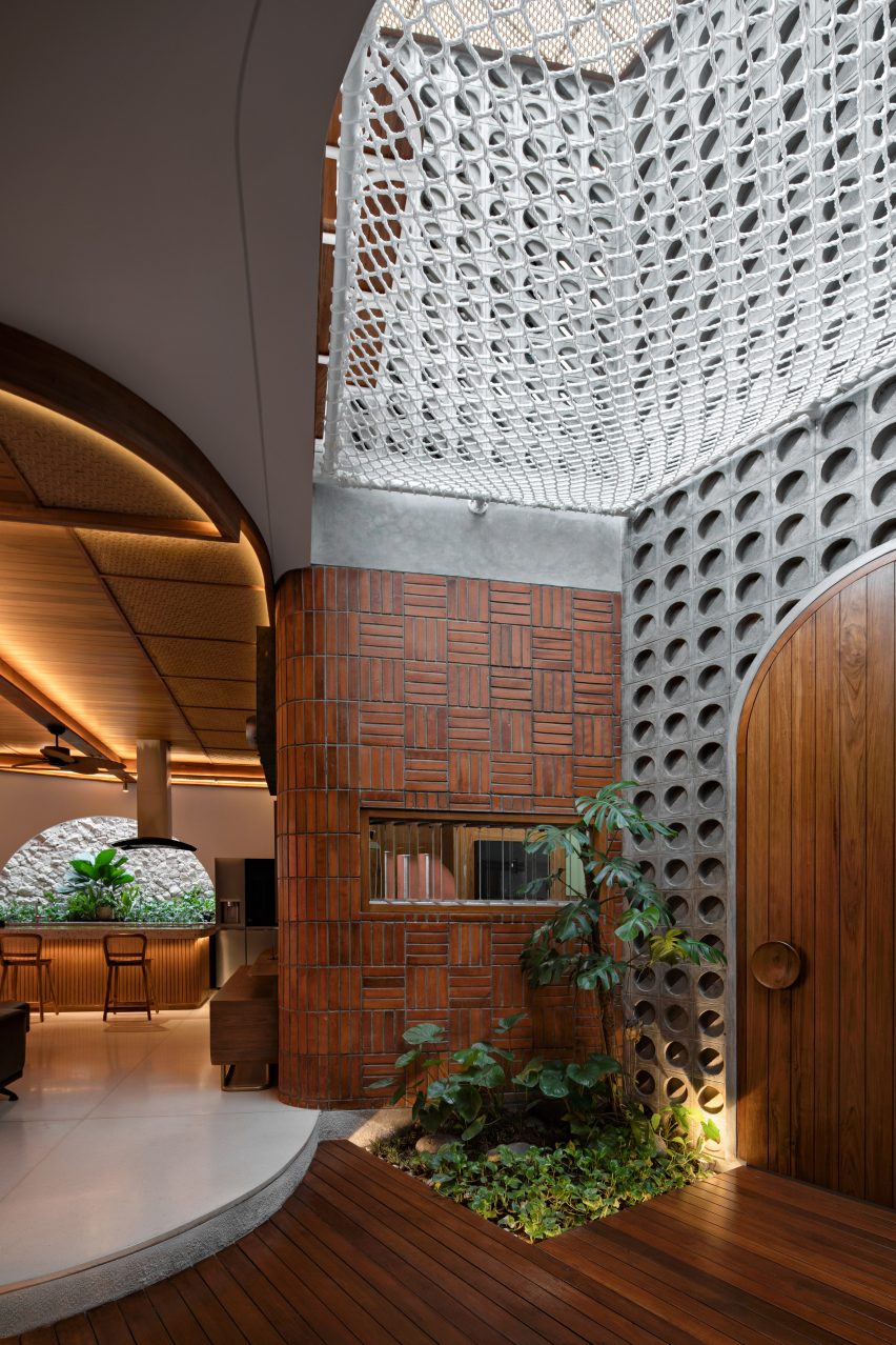 Concrete and wood light well at Distracted House by Ismail Solehudin Architecture