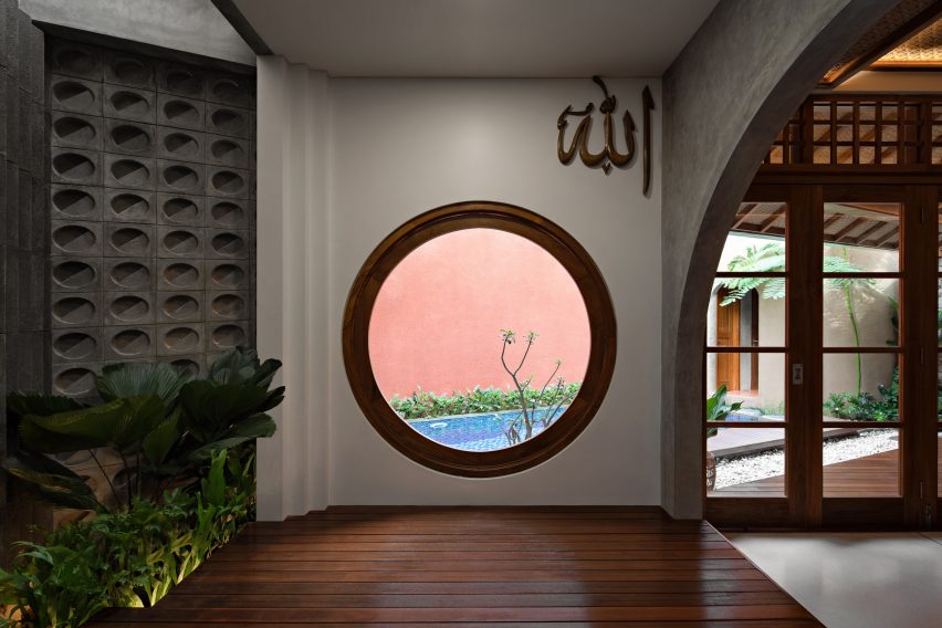 Circular window in a home looking onto a swimming pool