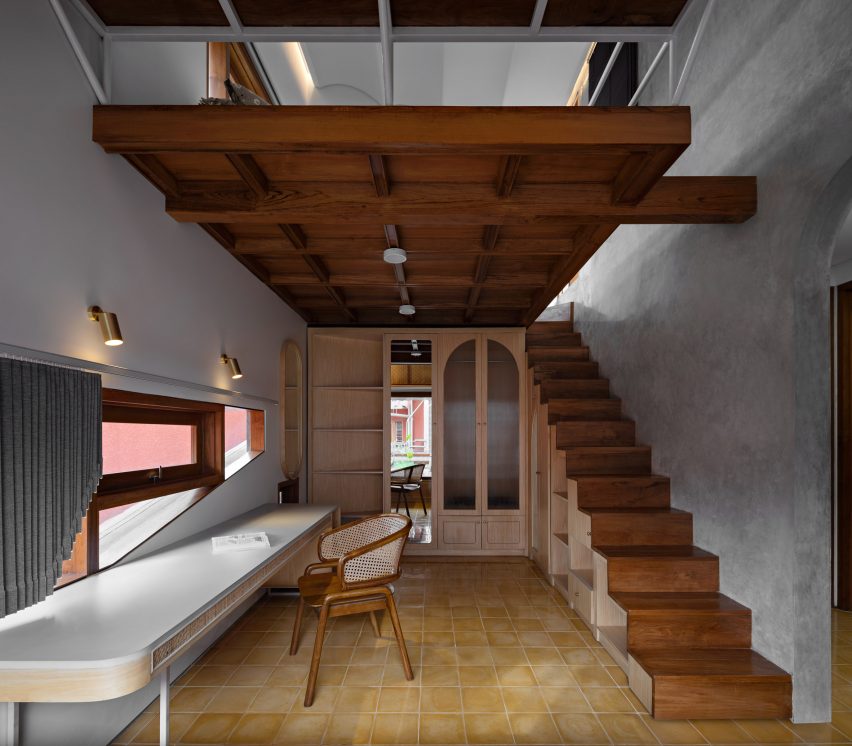 Concrete and wood interior with a mezzanine level at Distracted House