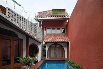 Courtyard swimming pool at a home in Jakarta with red-tiled roofs