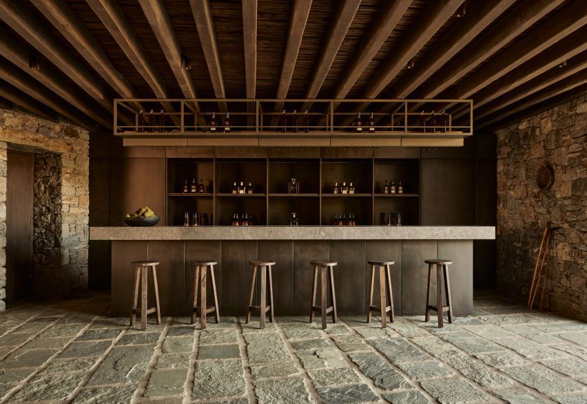 Bar with stools in a room with stone flooring and timber ceiling beams