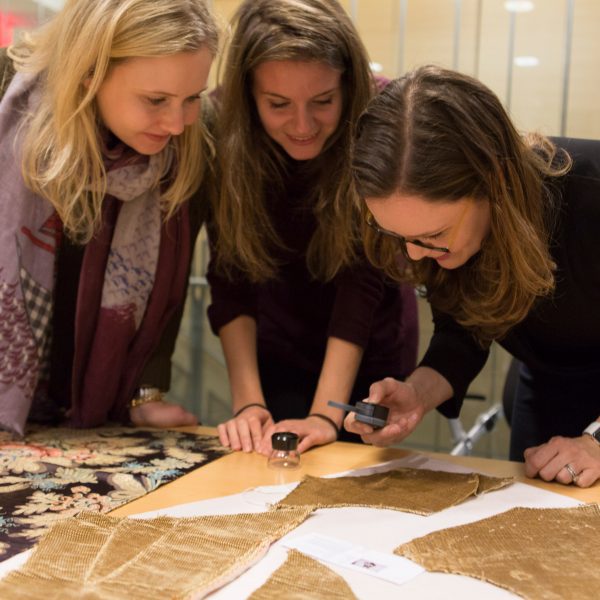Three students at Bard Graduate Centre studying fabrics