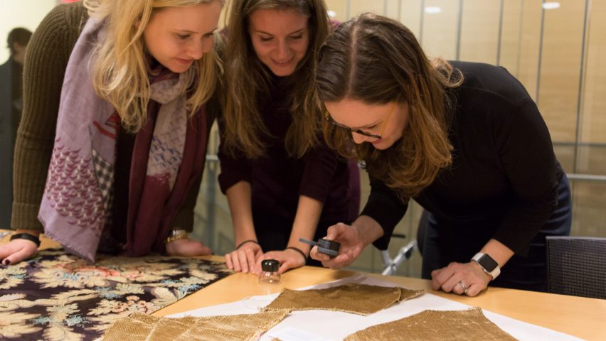 Three students at Bard Graduate Centre studying fabrics