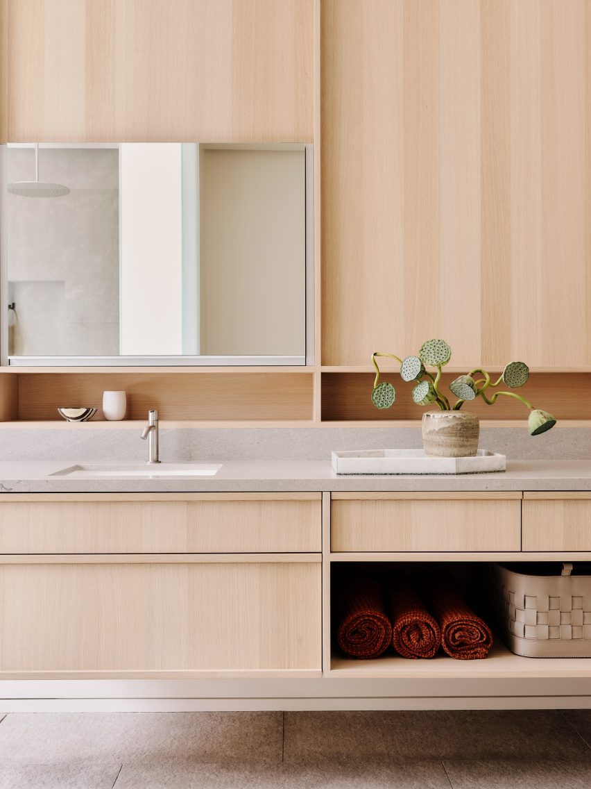 a bathroom with light wood cabintry