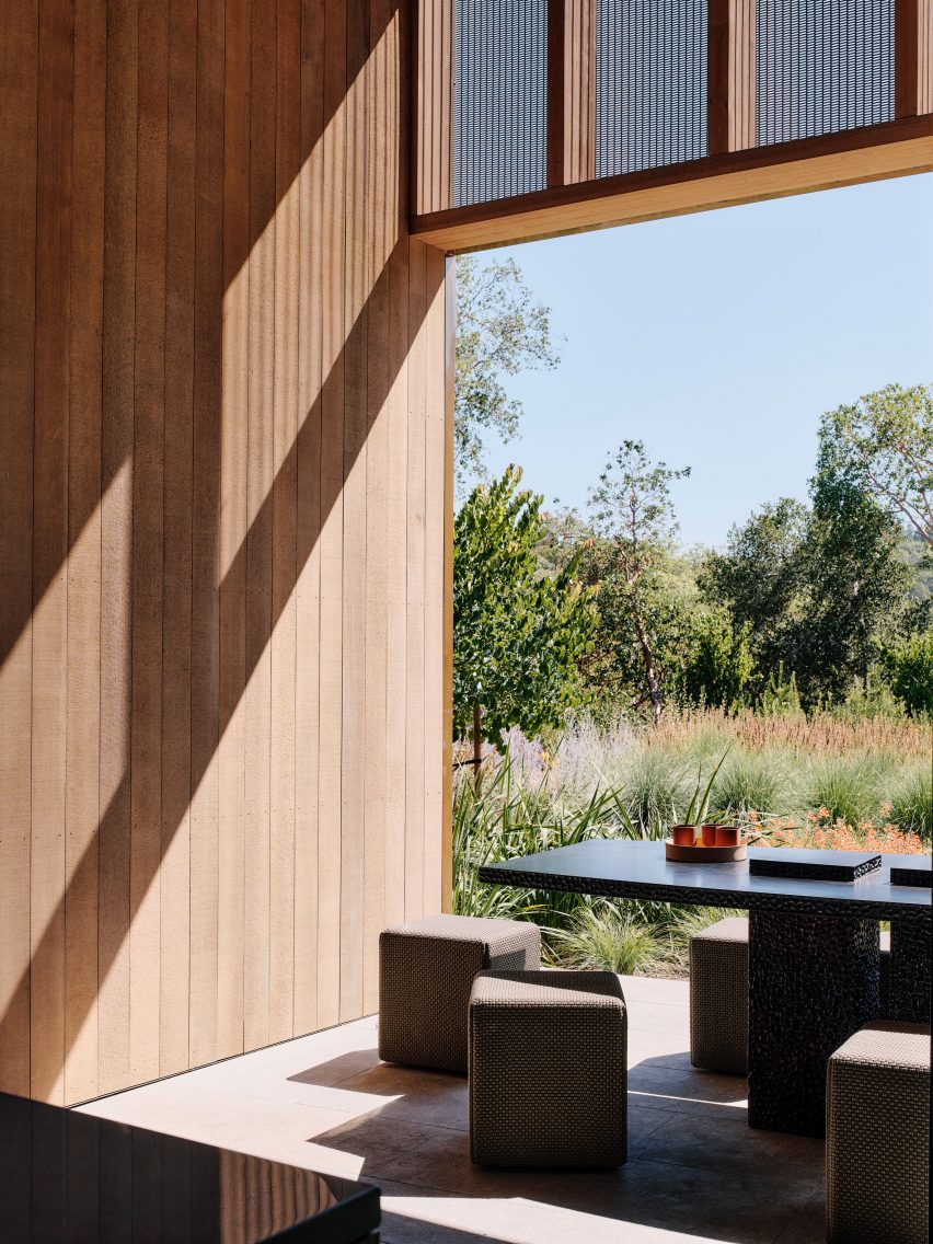 A living room with open walls and light wood cabintry