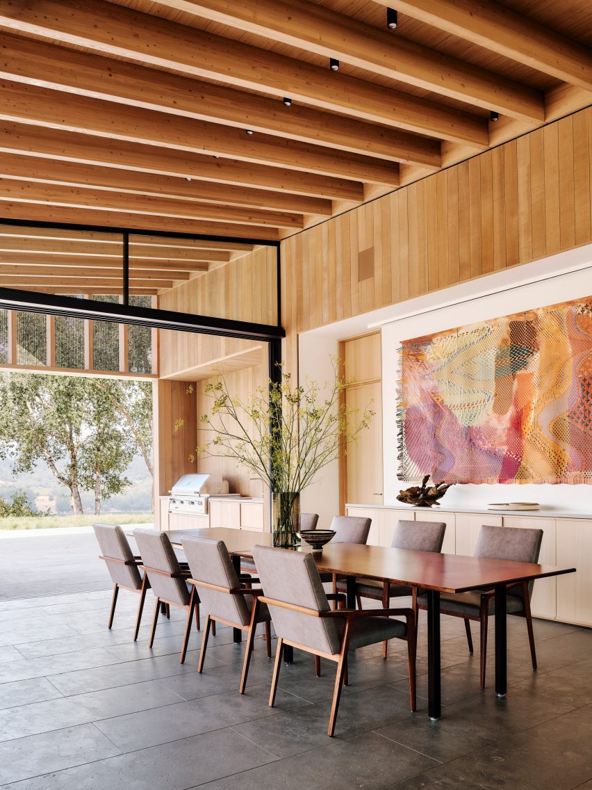 A dining room with large art and post and beam ceiling