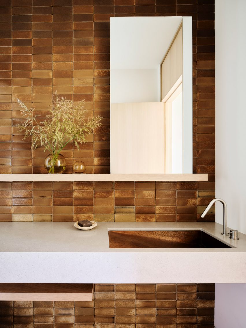 A bathroom with amber colored bricks