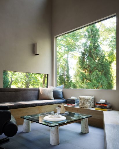 Seating area with large picture windows that face the woodland