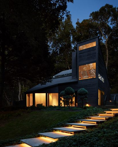 "Lily pad" steps lead up to the front of a black-painted residence 