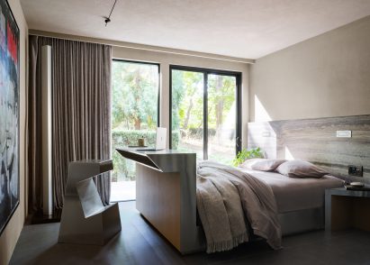 Guest bedroom featuring a bed with a desk built at its foot