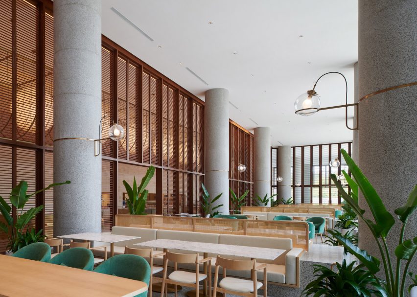 Hotel dining space with wood furniture and planting