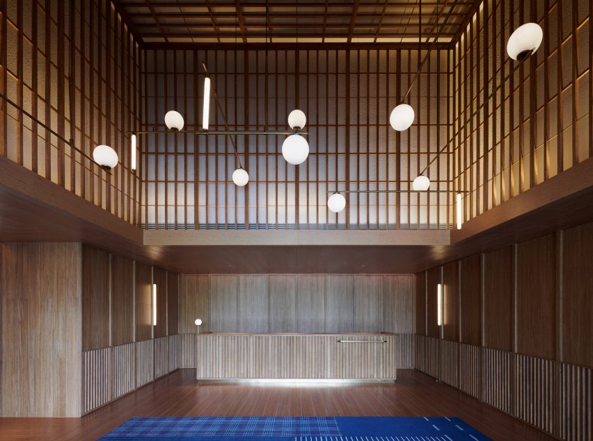 Wood-clad hotel interior with spherical lantern lights