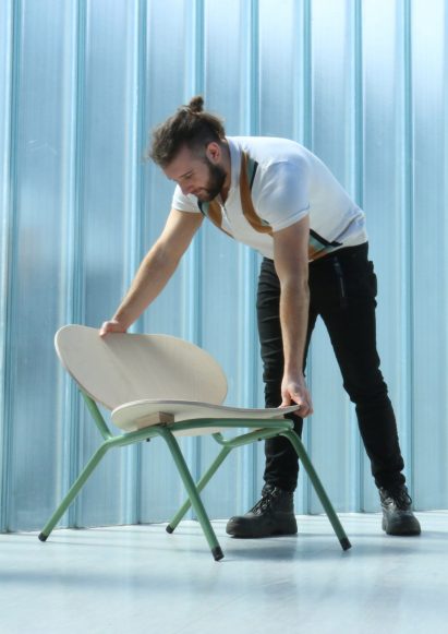 Person adjusting a plywood chair with green legs