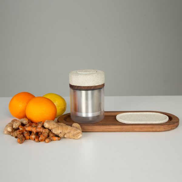 Photograph of oranges, lemons and ginger beside a juicing device