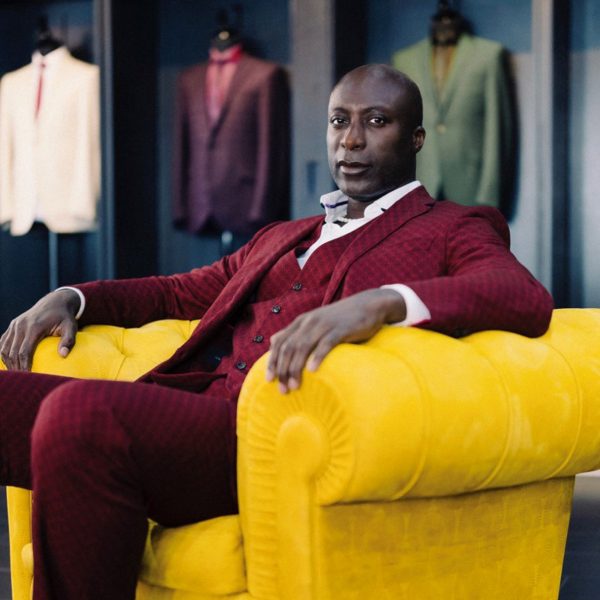 Ozwald Boateng sitting in yellow Chester armchair with embossed leather finish by Poltrona Frau