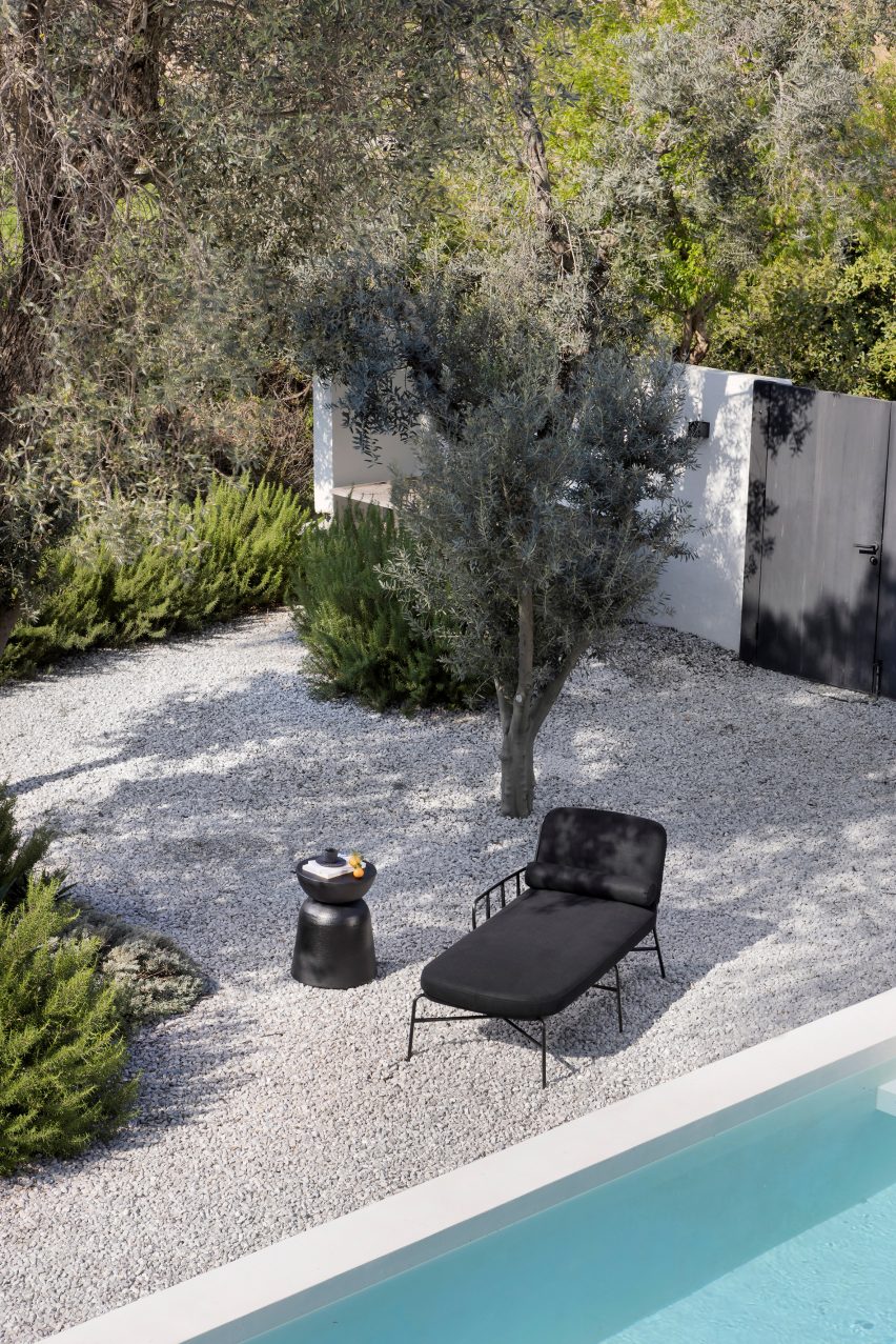 Black daybed next to a pool