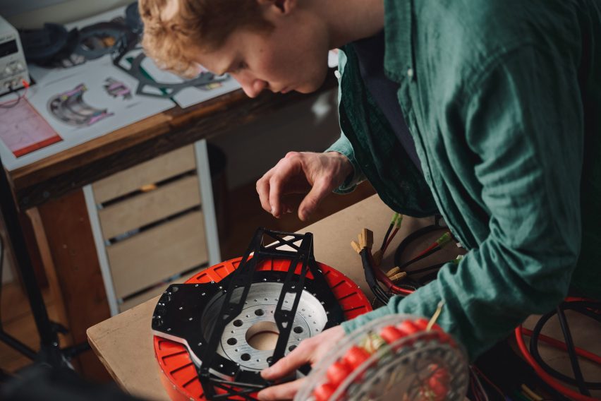 Photo of engineering student Alexander Burton tinkering with his REVR motor prototype