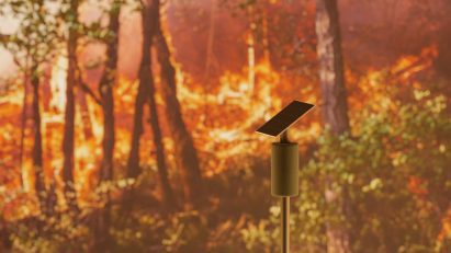 Solar Lookout wildfire detection system situated in a forest on fire