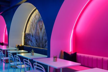 A trio of arched niches lit up in pink and yellow