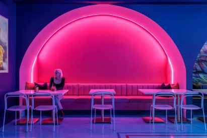 Pink arched niche with built-in seating and dining tables