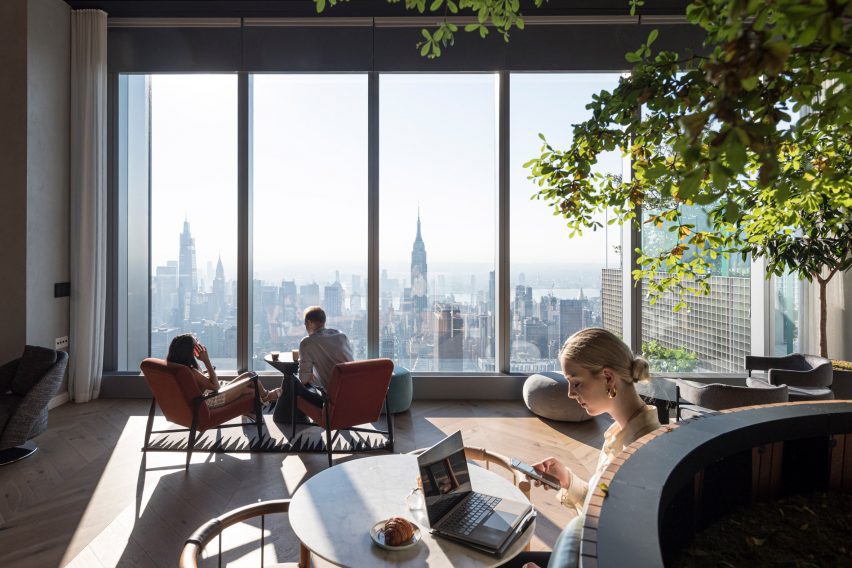 People reading in a public space in the uppermost floors of a skyscraper