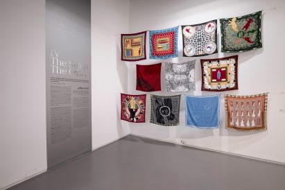 Photo showing a corner of an exhibition with 11 scarves hung up