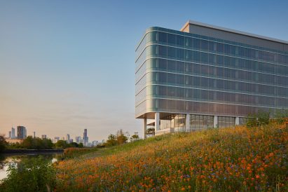 Glass-wrapped building overlooking the Chicago River and the city skyline beyond