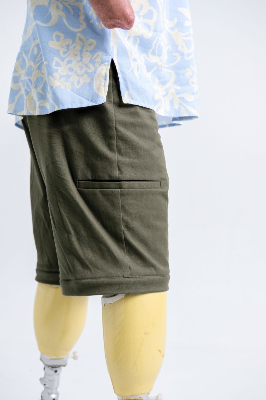 Close-up photo of a person with prosthetic legs wearing Will&Well's Convertible Cargo Pants with the bottoms zipped off to transform them into shorts