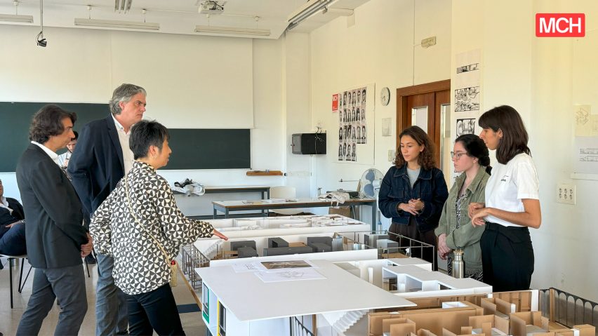 Photograph of students and lecturers discussing work that is on show.