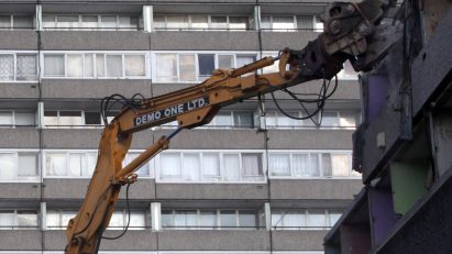 A crane tearing down buildings on the Aylesbury Estate in London