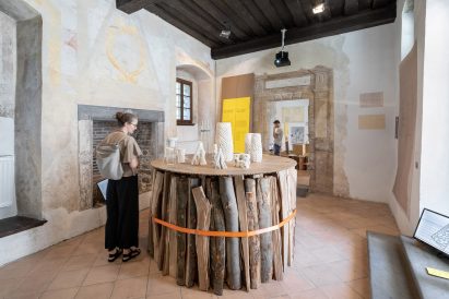 Table made from a stack of vertical logs and a cardboard top