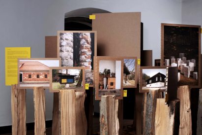 Photos and texts mounted onto honeycomb cardboard placed on top of logs
