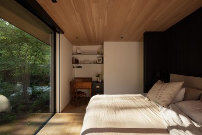 Bedroom with neutral tones facing a large picture window