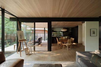 Living room with wooden floor and ceiling, looking towards the dining room