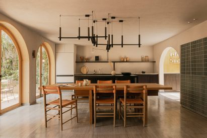 Minimal kitchen with dark cabinetry and a large wooden dining table