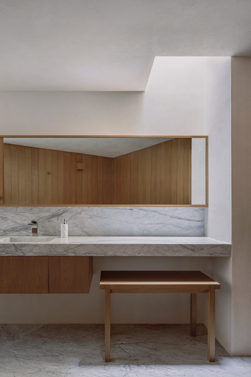 Bathroom with marble surfaces and wood furniture
