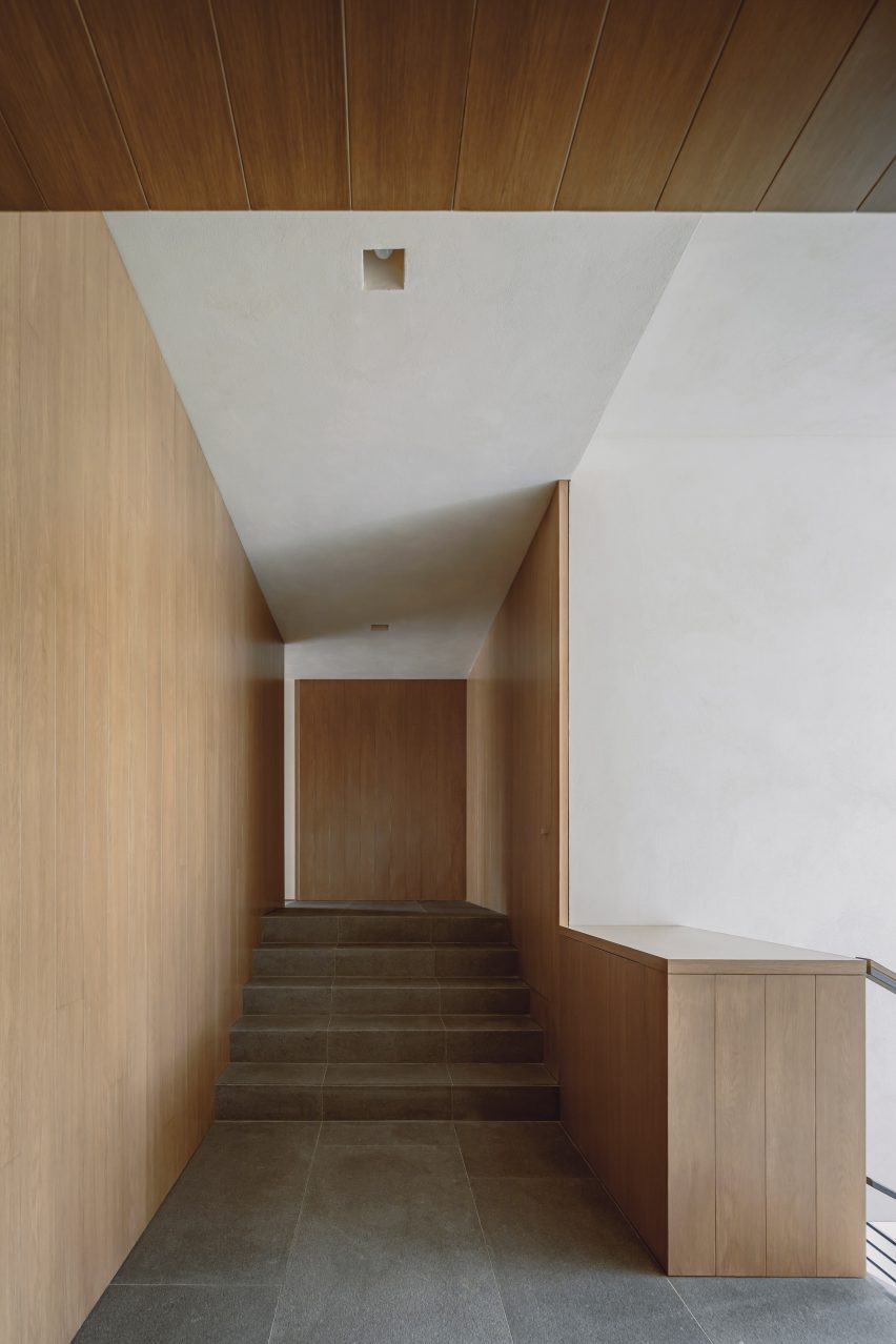 Staircase landing with wood-lined walls