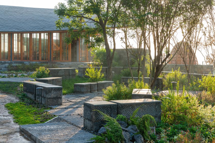 Stone seating in a garden outside the Dapi Mountain Restaurant by Galaxy Arch