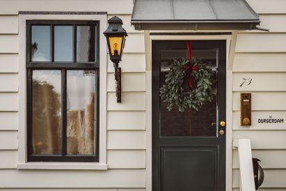 Front door of hotel with white weatherboarded facade